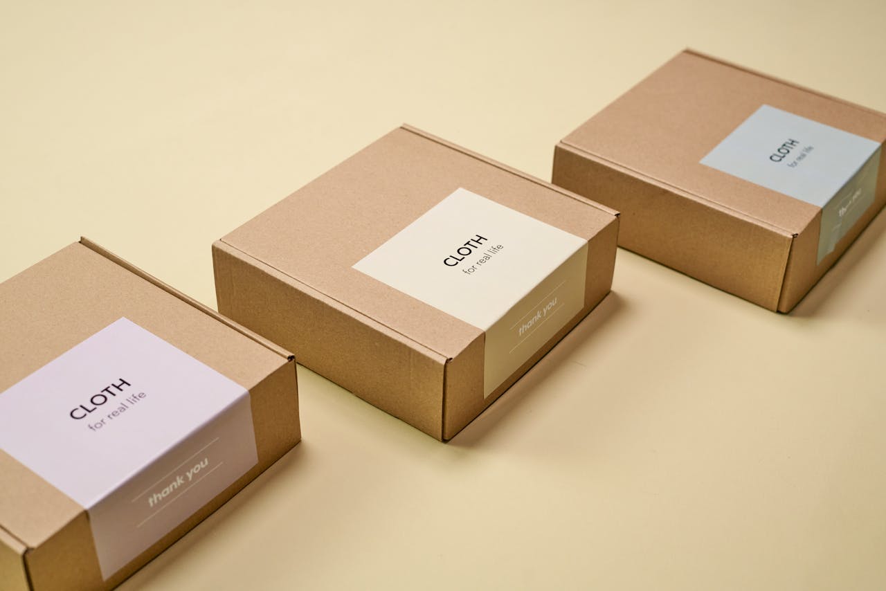 portfolio-01 Three minimalist cardboard packages labeled 'CLOTH' on a yellow background.